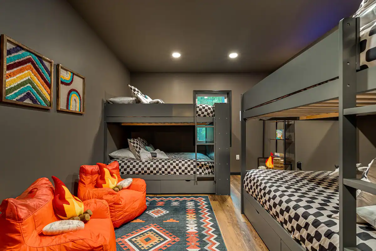 The Retreat's kids' sanctuary bursts with vibrant colors and playful charm, offering kids' books, giant Jenga, and TV with four full-size beds to accommodate "kids" of all sizes.