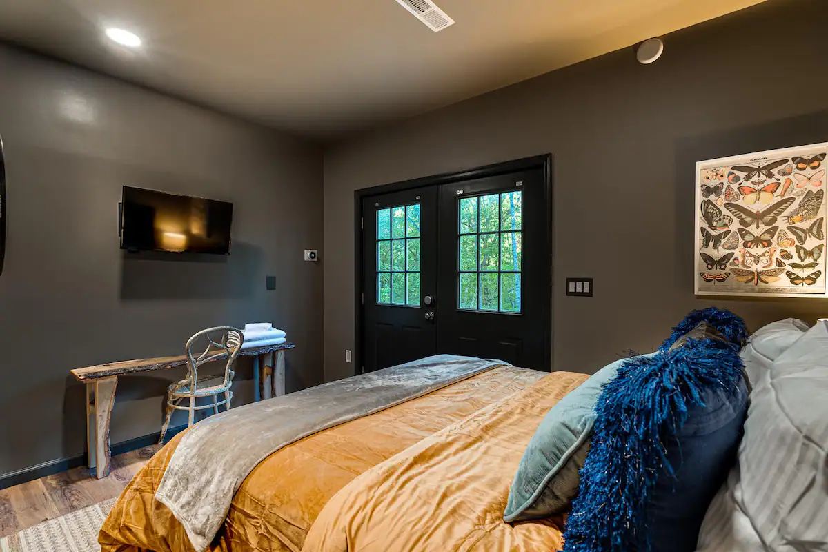 The Retreat's Queen Bedroom with Private Access: Offering a serene queen bed and exclusive access to the back of the house for added privacy.