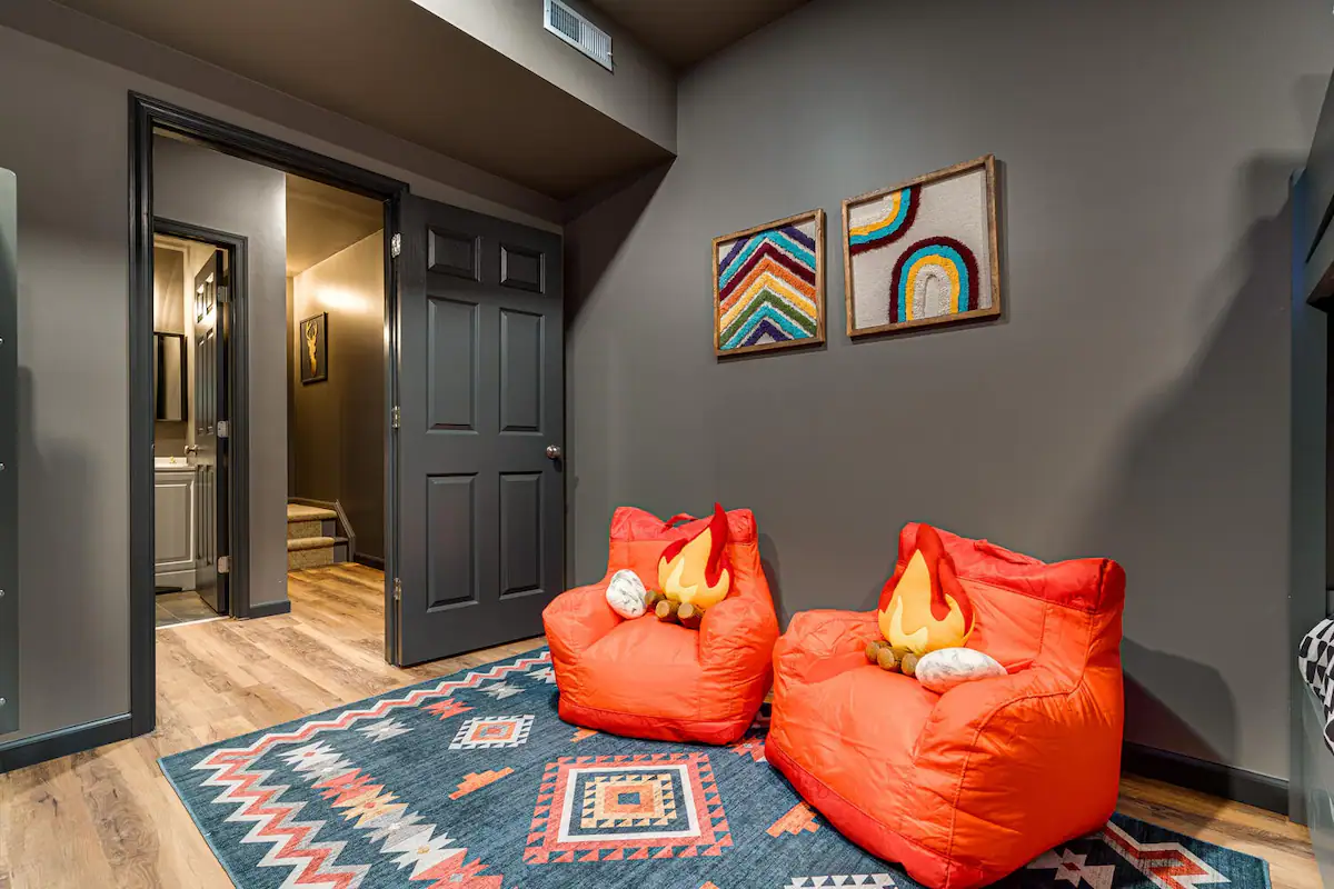 The Retreat's kids' sanctuary bursts with vibrant colors and playful charm, offering kids' books, giant Jenga, and TV with four full-size beds to accommodate "kids" of all sizes.